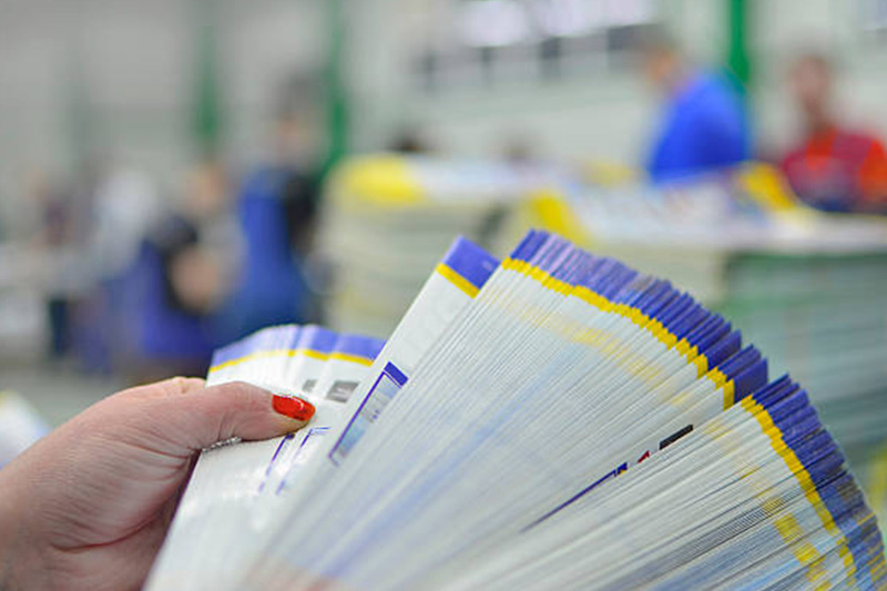 Lady thumbing through a stack of printed material